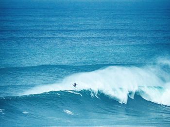 Distant view of man surfing in sea 