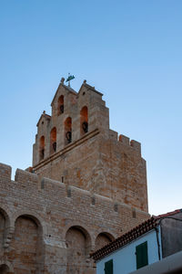 Low angle view of historic building against clear blue sky