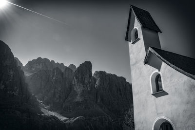 Low angle view of chapel and mountain against sky