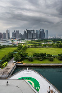 Aerial view of swimming pool by buildings in city against sky