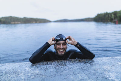 Smiling man resting at edge of lake