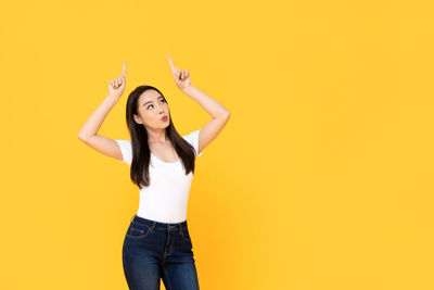 Portrait of a young woman against yellow background
