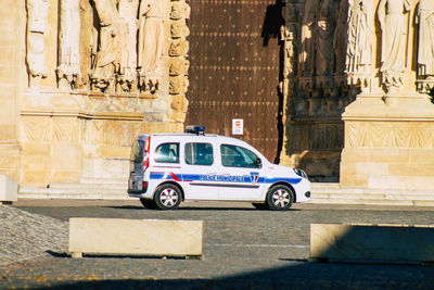 Police car on street against ancient sculptures