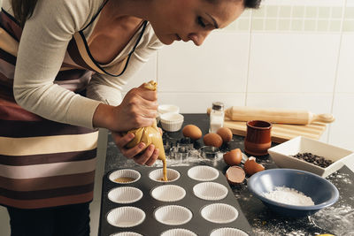 Woman preparing food in kitchen at home