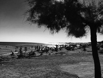 People on beach against clear sky