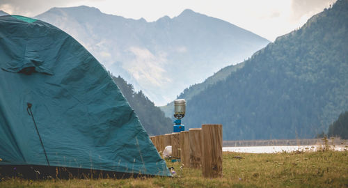 Tent on field by mountains against sky