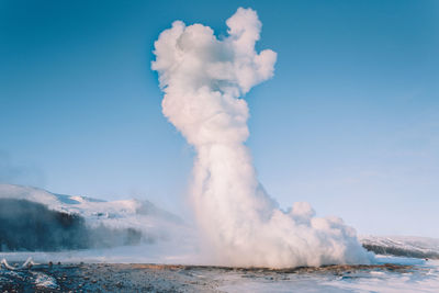 Scenic view of geyser against sky