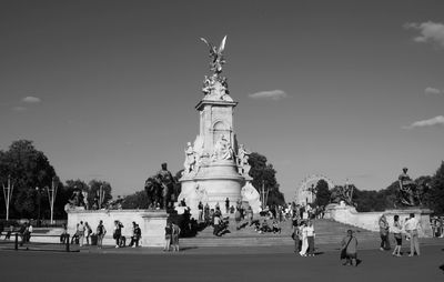 Tourists in front of liberty against sky