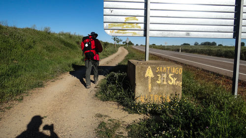 Man walking on road against sky