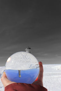 Person holding ice cream against sky