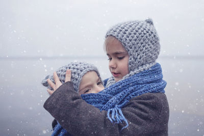 Portrait of mother and daughter in snow during winter