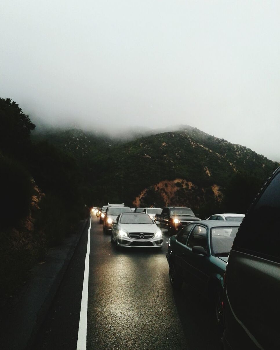 VEHICLES ON ROAD AGAINST SKY