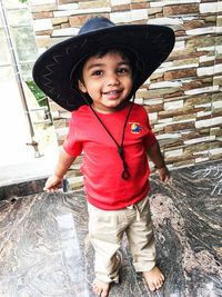 Portrait of cute boy wearing hat while standing outdoors