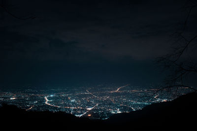 Illuminated cityscape against sky at night