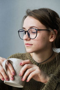 Millennial brown-haired girl drinks tea with cakes alone