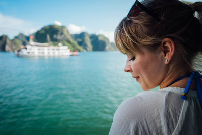 Close-up of woman at lake against sky