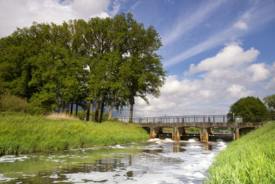 Arch bridge over river against sky