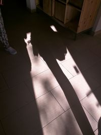 Low section of person shadow on floor