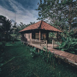 House amidst trees and building against sky