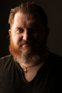 Close-up portrait of man against black background