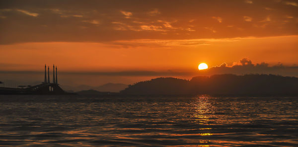 Scenic view of sea against orange sky