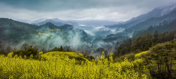 Scenic view of mountains against cloudy sky