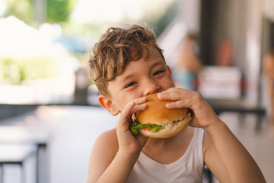 Portrait of boy eating burger