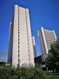 Low angle view of modern buildings against clear blue sky