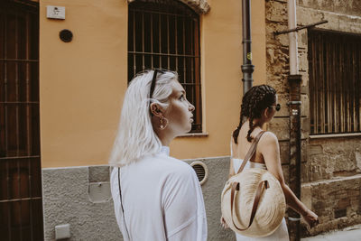 Rear view of woman standing outside building