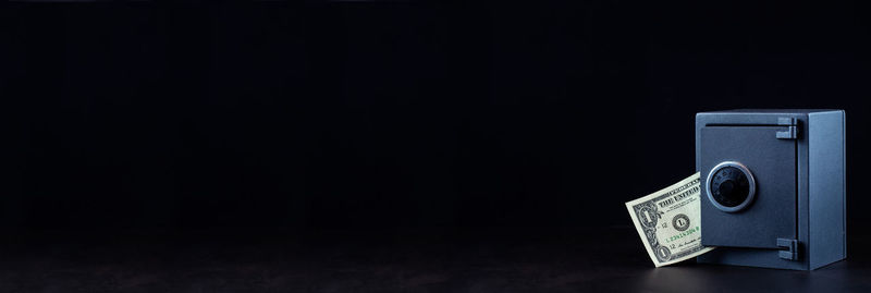 Close-up of camera on table against black background