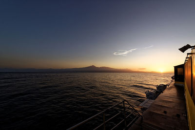 Boat in sea against sky during sunset