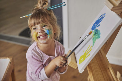 Charming child draws and stains everything with paints