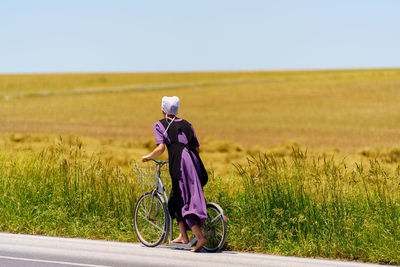 Side view of woman cycling on road