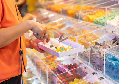 Woman use pliers selective jelly to buy in street food market.