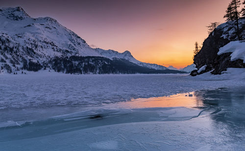 Scenic view of snowcapped mountains against sky during sunset