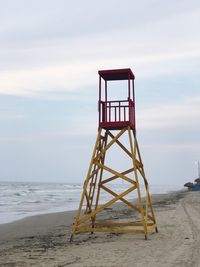 Lifeguard hut on beach against sky