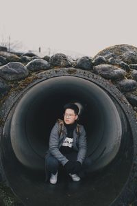 Portrait of young man standing against sky