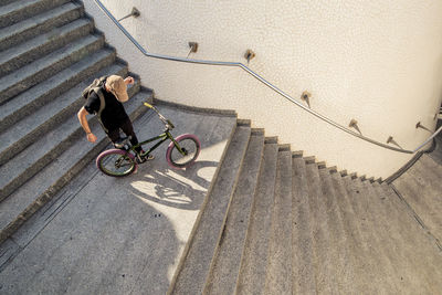 High angle view of man with bicycle on staircase