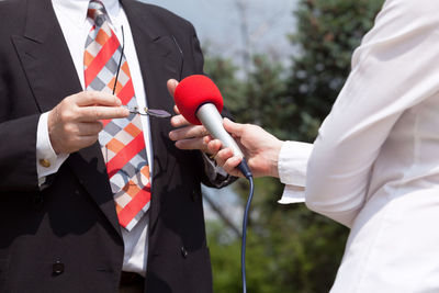 Midsection of woman taking interview of businessman