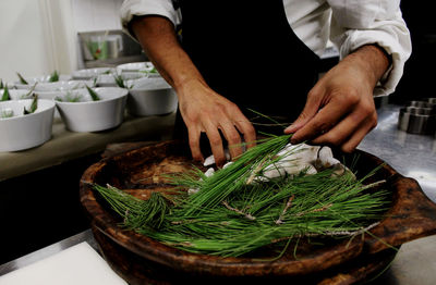 Mid section of chef at work