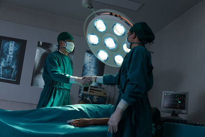 Surgeons shaking hands in operating room