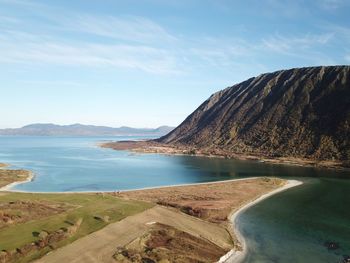 Scenic view of sea and mountains against sky