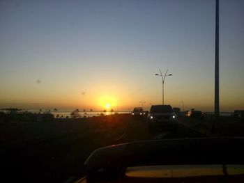 Silhouette city against clear sky during sunset