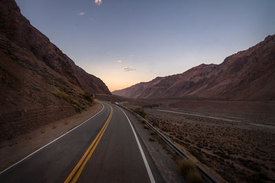 Empty road against sky during sunset