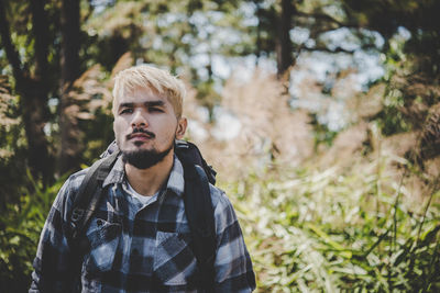 Young man standing at forest