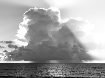 Sunlight streaming through clouds over sea