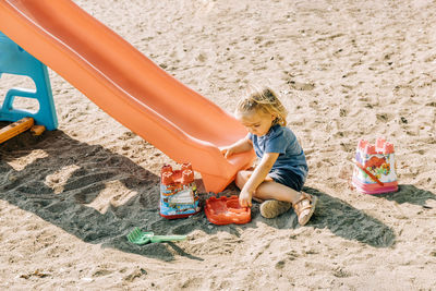High angle view of boy playing with toy on sand