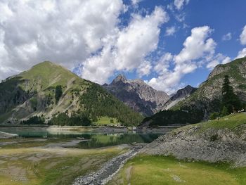 Scenic view of lake by mountains against sky