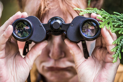 Close-up of woman holding binoculars
