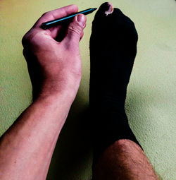 Low section of man holding shoe